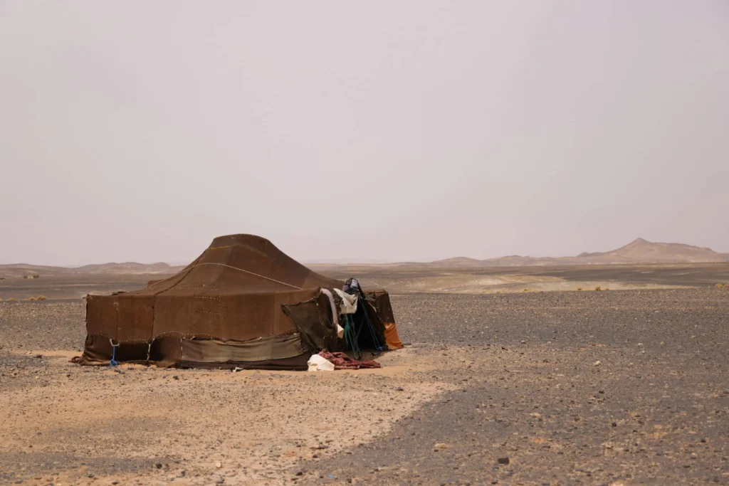 Traditional Amazigh nomadic tent in the rocky Sahara desert landscape near Merzouga, Morocco