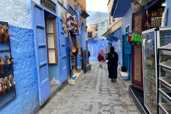 Narrow blue alleyway with people in chefchaouen